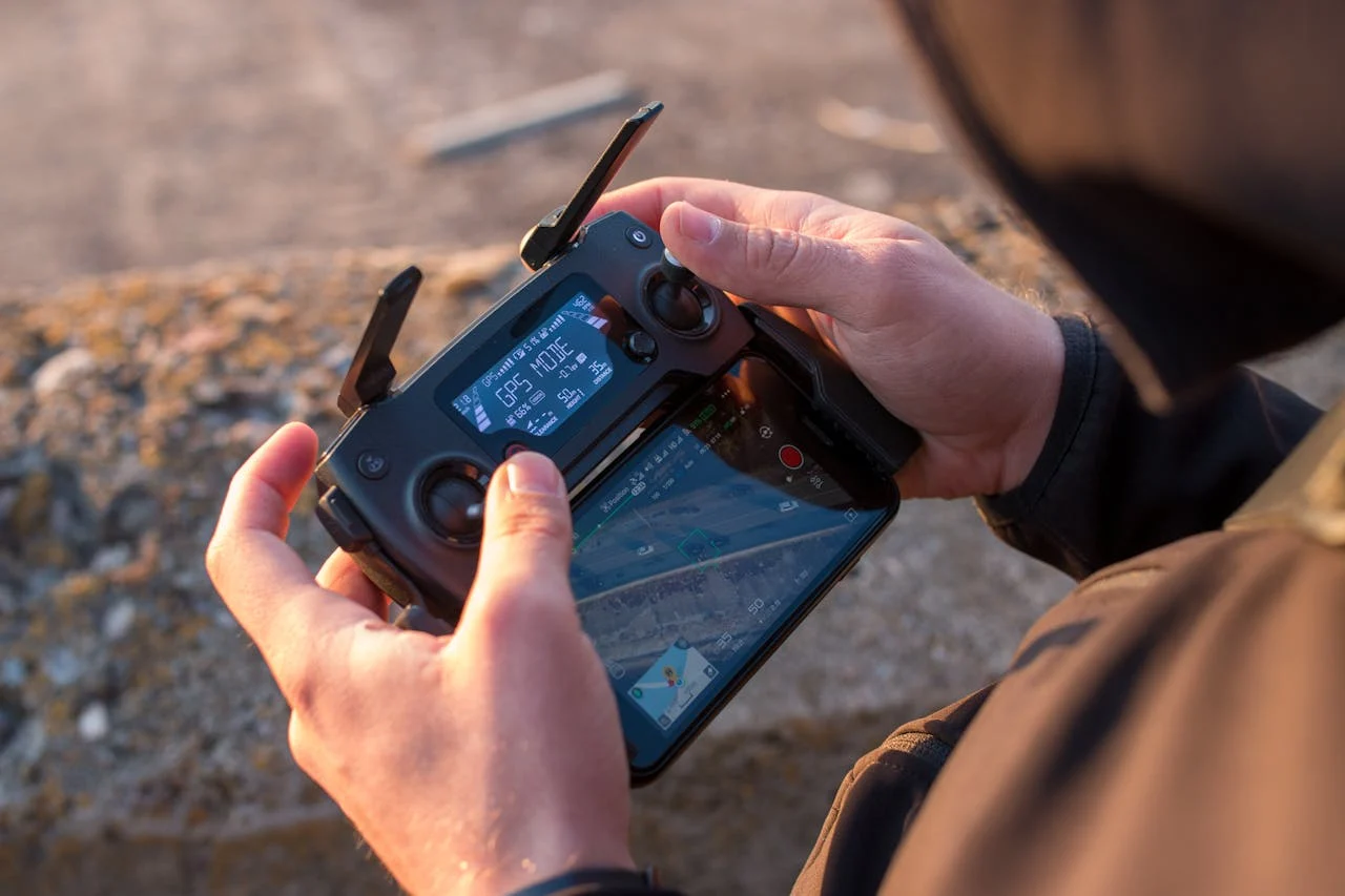 Close-up of a person operating a drone with a controller outdoors